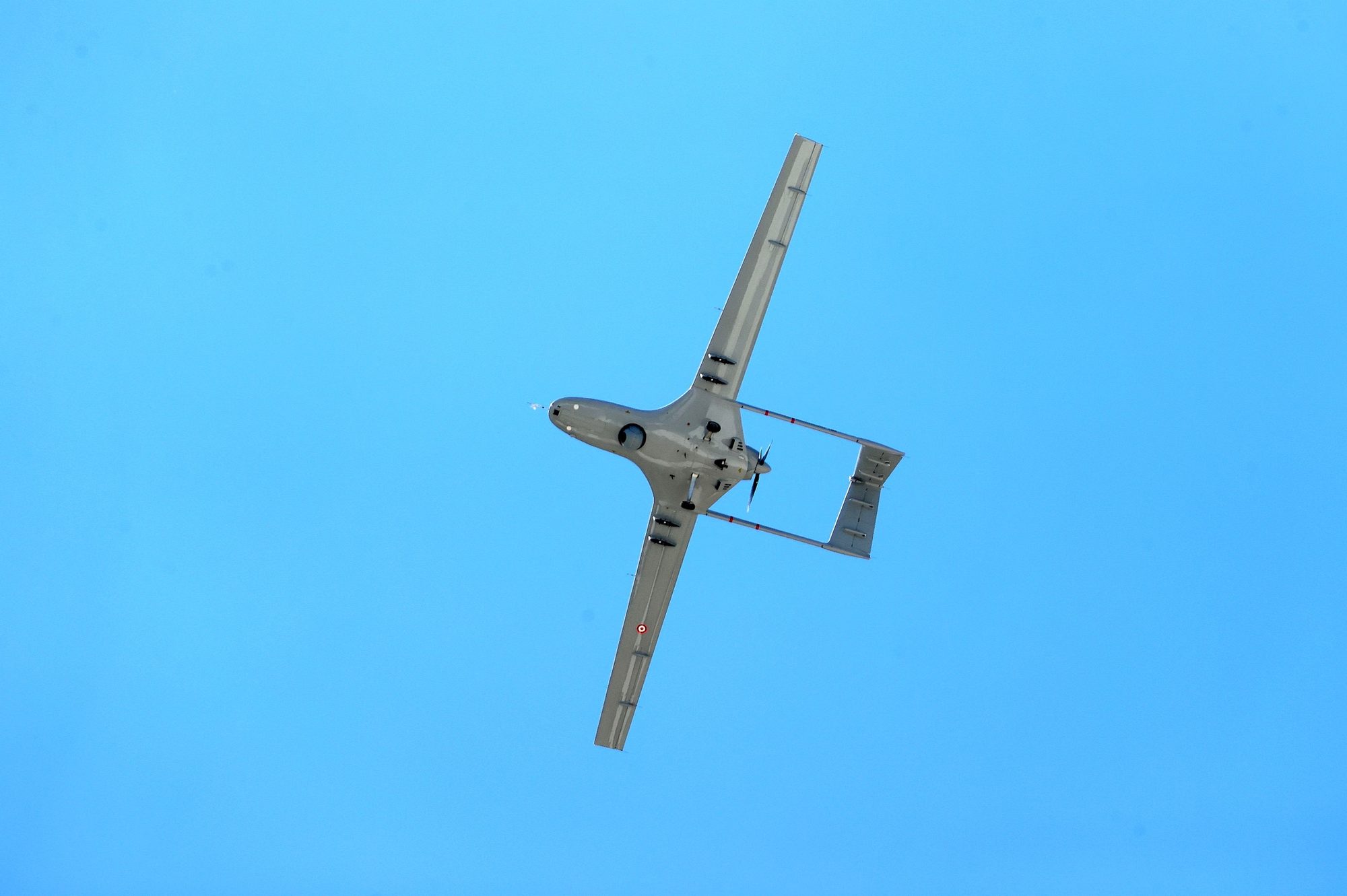 Starrflügler-Drohne im Flug vor blauem Himmel